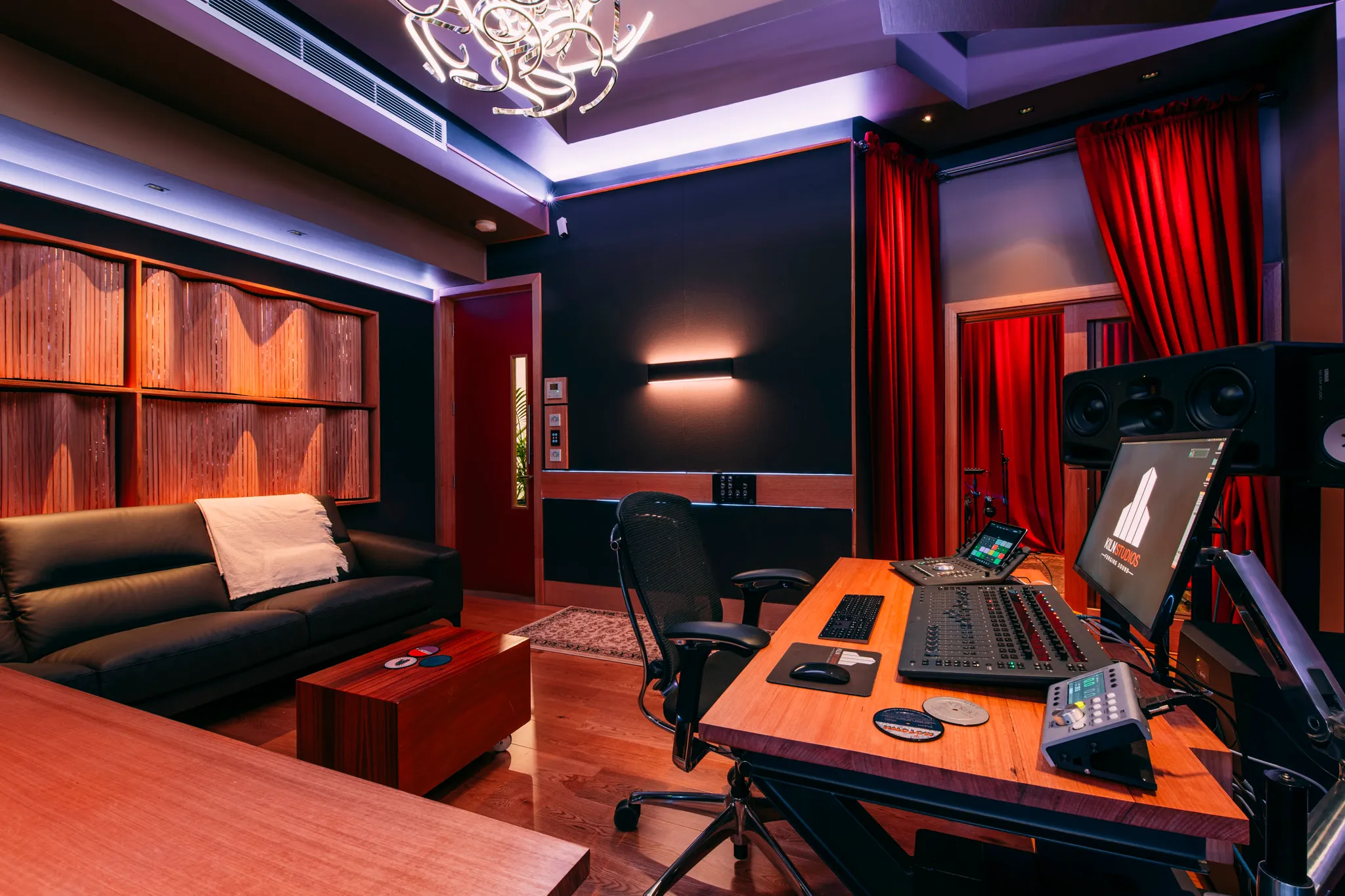 Studio 1 at Kiln - the control room under violet light, red curtains to the booth