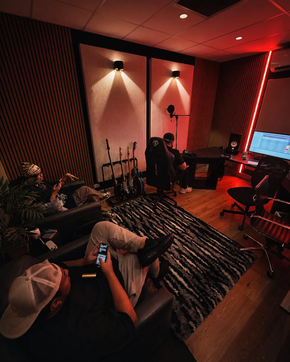 Studio 3 at Kiln - the production room under red light, guitars racked along the wall